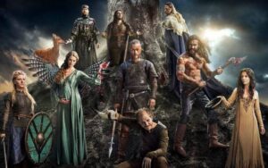 Actores principales de la serie vikingos posando juntos al pie de una montaña, en un paisaje natural que refleja la ambientación nórdica
