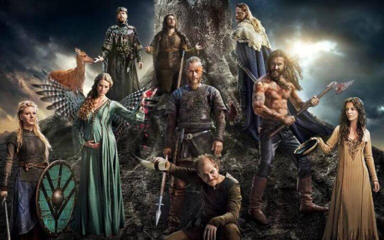 Actores principales de la serie vikingos posando juntos al pie de una montaña, en un paisaje natural que refleja la ambientación nórdica