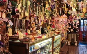 Artículos esotéricos Hoodoo exhibidos en una tienda espiritual, con velas, raíces, aceites y objetos rituales tradicionales